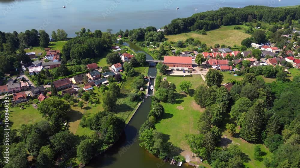 canal lock sluice being used by boats on a sunny summer day in germany Himmelpfort countryside Brandenburg. Dramatic aerial view flight drone shot footage from above