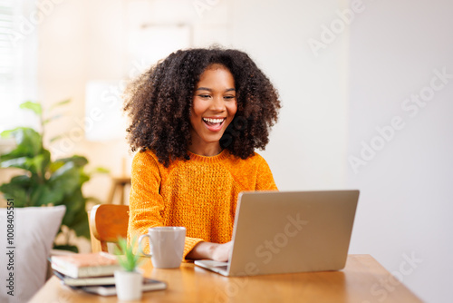 African American in Afro hair or girl using laptop computer learning distantly online sitting at desk at home. web education and E-learning 