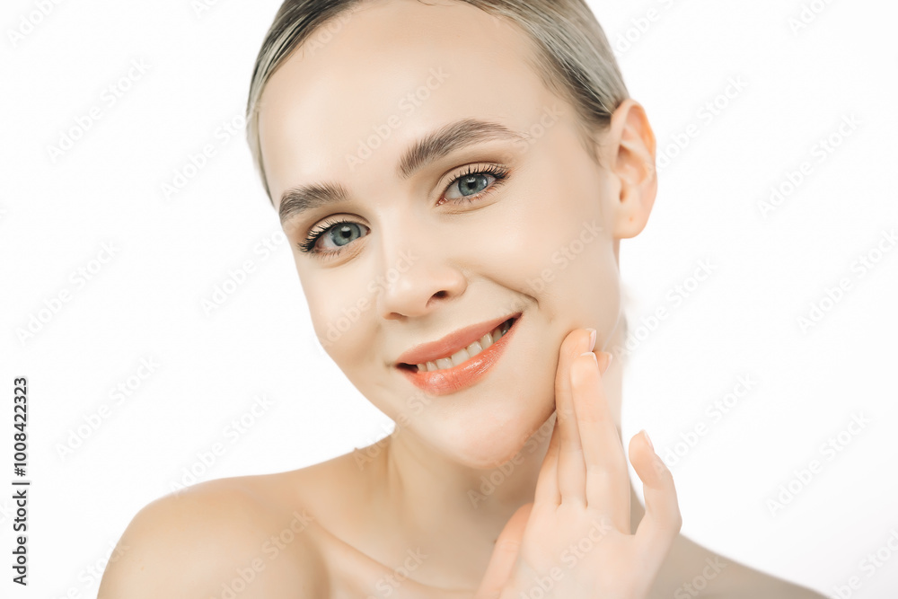 A beautiful young woman touches her skin against a white background, showcasing her clean, flawless face. This image emphasizes the importance of skincare and aesthetic treatments. A beautiful young woman touches her skin against a white background, showcasing her clean, flawless face. This image emphasizes the importance of skincare and aesthetic treatments.