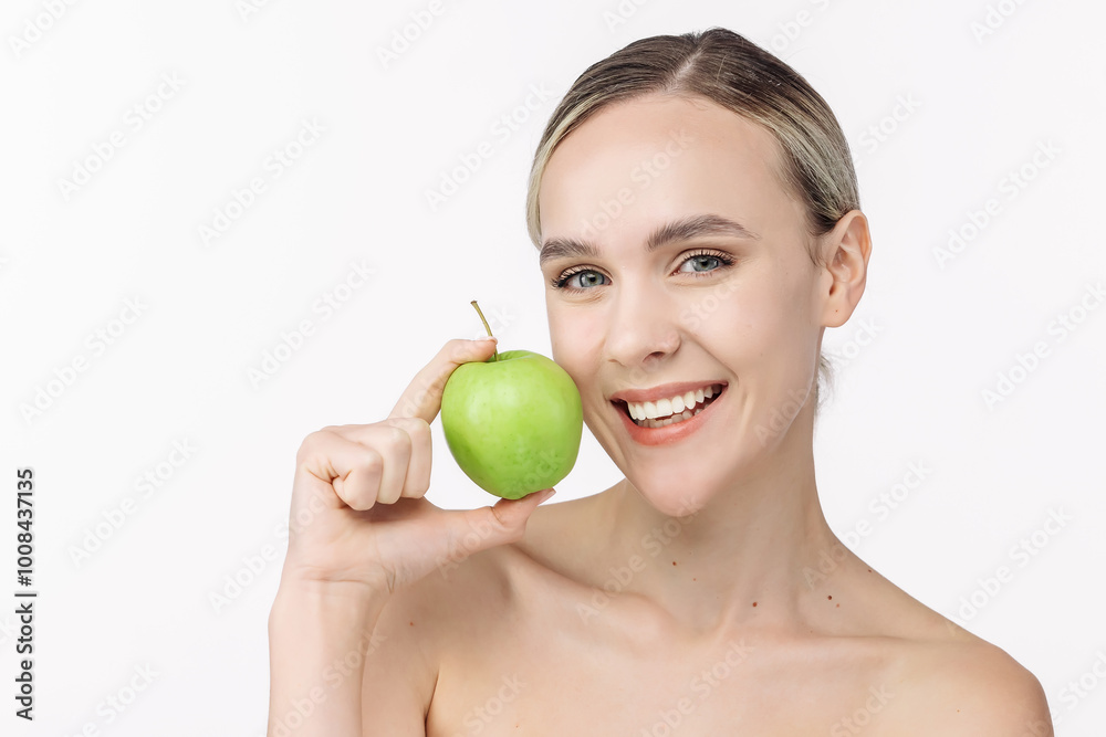 Young woman smiling, holding a green apple on a clean white background. This snack reflects her active lifestyle and commitment to health. Young woman smiling, holding a green apple on a clean white background. This snack reflects her active lifestyle and commitment to health.