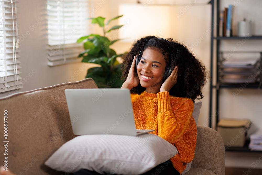 Happy millennial African American woman sitting on couch at home, get pleasant online message on laptop, chatting with friends via video call, talking in video chat, gestures with her hands.
Happy millennial African American woman sitting on couch at home, get pleasant online message on laptop, chatting with friends via video call, talking in video chat, gestures with her hands.