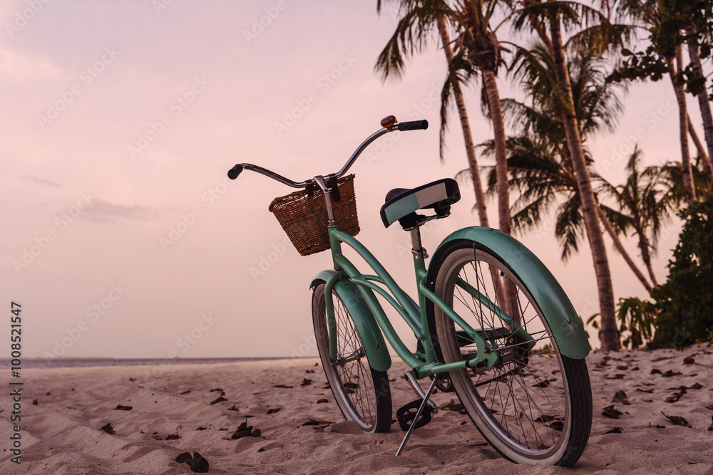 Fototapeta premium Vintage Beach Cruiser Bicycle on Sandy Beach at Sunset with Palm Trees