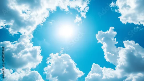 Fototapeta Bezchmurne niebo w odcieniach głębokiego błękitu jest ozdobione puchatymi, białymi chmurami, które delikatnie suną po horyzoncie. 
