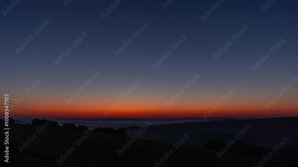 Timelapse from night to day over german Eifel landscape with beautiful sunrise over foggy fields, Eifel, Germany Timelapse from night to day over german Eifel landscape with beautiful sunrise over foggy fields, Eifel, Germany