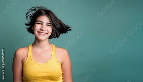 a teenage girl wearing a yellow tank top smiling at the camera wearing a yellow tank top photo