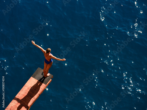 a female professional swimmer about to dive into the sea