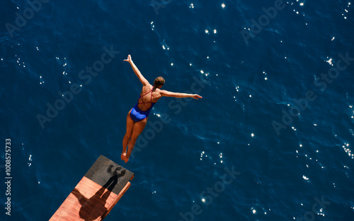 a female professional swimmer about to dive into the sea