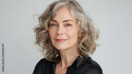 portrait of a beautiful middle-aged Caucasian woman with well-skinned face looks at the camera, studio portrait, white background.