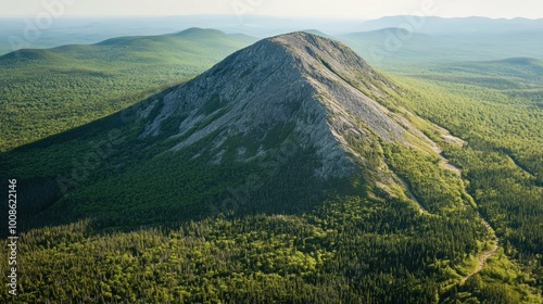 Aerial view of Bald Mountain, its rocky summit standing stark against the surrounding forested slopes, with winding trails visible below.