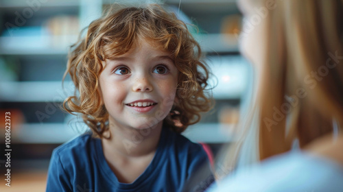 Caucasian smiling boy 5-6 years old talking with speech therapist or psychologist during classes