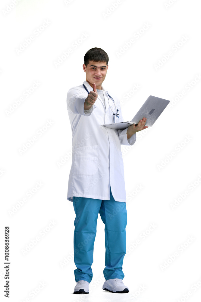 The doctor, in full height, on a white background, uses a laptop The doctor, in full height, on a white background, uses a laptop