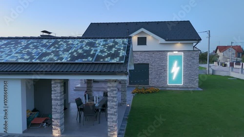 Sustainable residential modern house with solar panels and animation of photovoltaic energy flow and battery charging. Environment friendly home. Aerial slide shoot