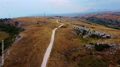 Majestic Aerial View of Remote Wilderness in Bosnia Herzegovina - Windmills, Scenic Valleys, and Rural Landscapes with Mountains, Meadows, and Tranquil Horizons in a Sunny, Dry Climate