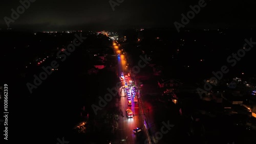 Accident on dark highway on rainy Day. Police, Fire Department and Ambulance helping injured people. Aerial orbit shot.