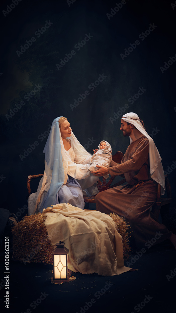 Fototapeta premium Holy and magical nativity scene with Mary gently holding baby Jesus with wise man, Joseph and shepherd standing around. Concept of Christmas, nativity scene, history, religion