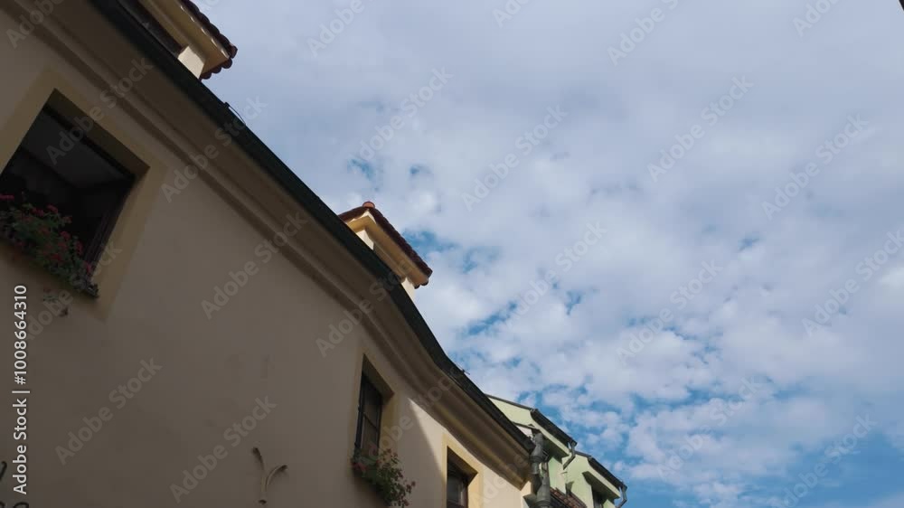 Low-angle shot of a charming building with flower boxes under a partly cloudy sky Low-angle shot of a charming building with flower boxes under a partly cloudy sky
