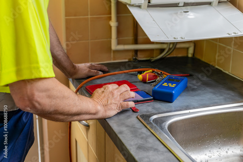 Papier peint Gas service engineer entering data into phone app beside boiler and and digital