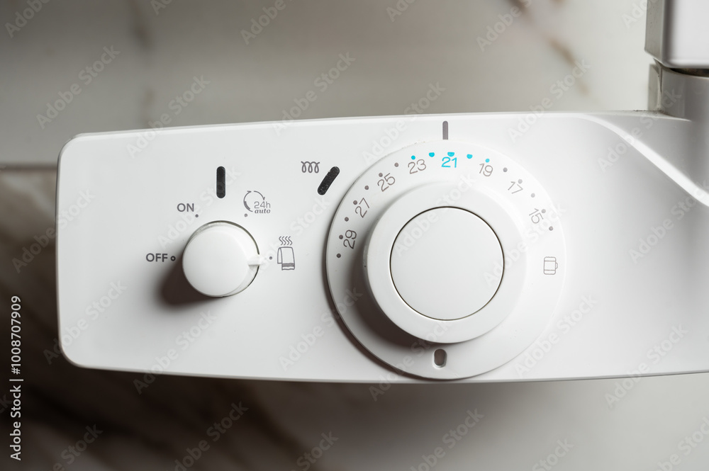 White temperature control on a heated towel rail in the bathroom. Control of heating modes. White temperature control on a heated towel rail in the bathroom. Control of heating modes.