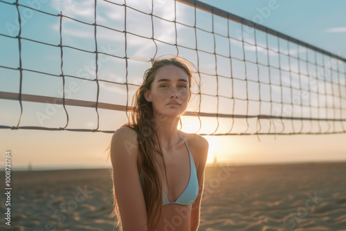 Young Woman Relaxing by a Beach Volleyball Net at Sunset photo