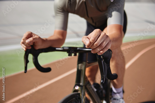 Closeup view on bicyclist holding hands on steering wheel driving bike