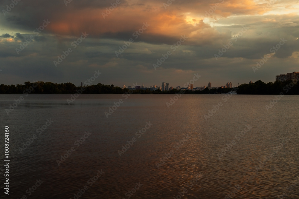 Bright sunset over lake, golden clouds reflect in the water Bright sunset over lake, golden clouds reflect in the water