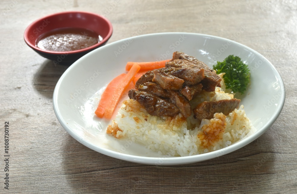 grilled slice pork topping rice with carrot and parsley on plate dipping barbecue sauce cup grilled slice pork topping rice with carrot and parsley on plate dipping barbecue sauce cup