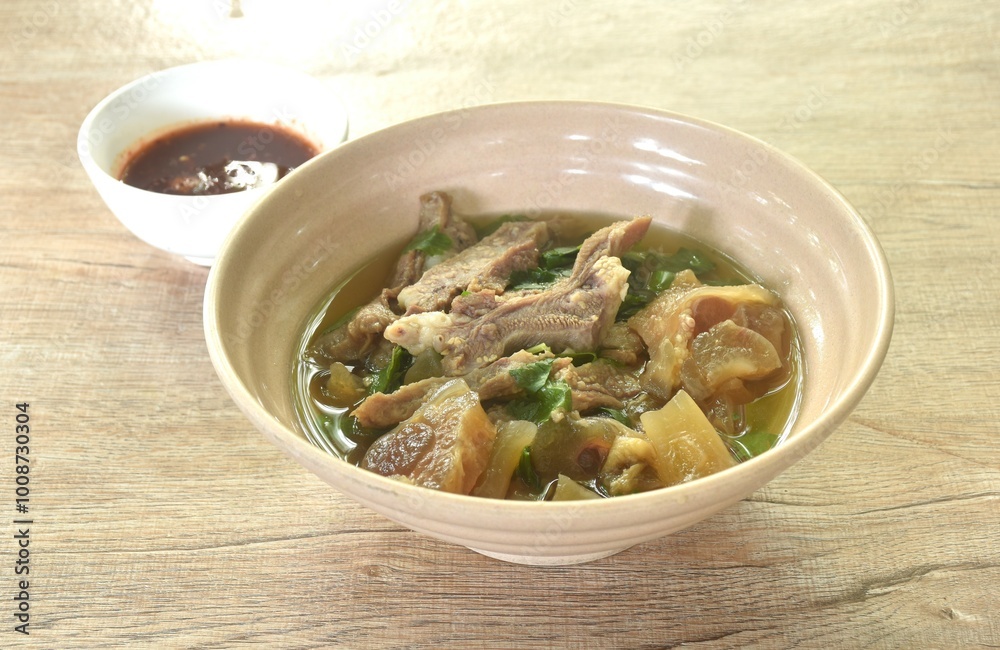 boiled braised beef meat and tendon in herb brown soup on bowl dipping spicy chili sauce boiled braised beef meat and tendon in herb brown soup on bowl dipping spicy chili sauce