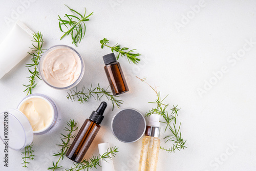 Clean beauty, eco organic natural cosmetics. Set of various cream, serum, moisturizing skincare cosmetics with green herbal leaves and sprigs, on white background copy space