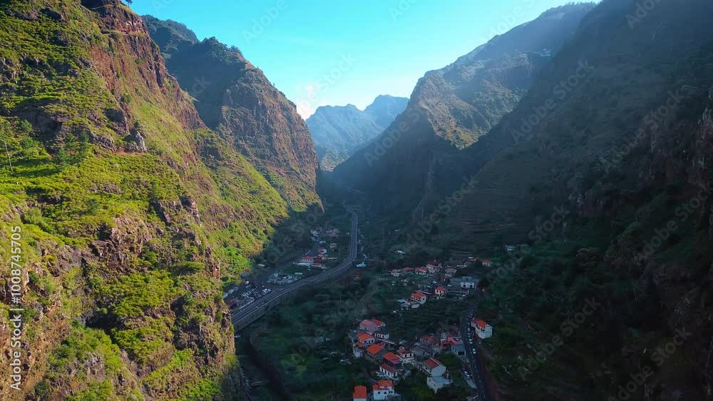 View on the town located between the high mountains. Amazing scenery of the Madeira Islands, Portugal from drone. View on the town located between the high mountains. Amazing scenery of the Madeira Islands, Portugal from drone.