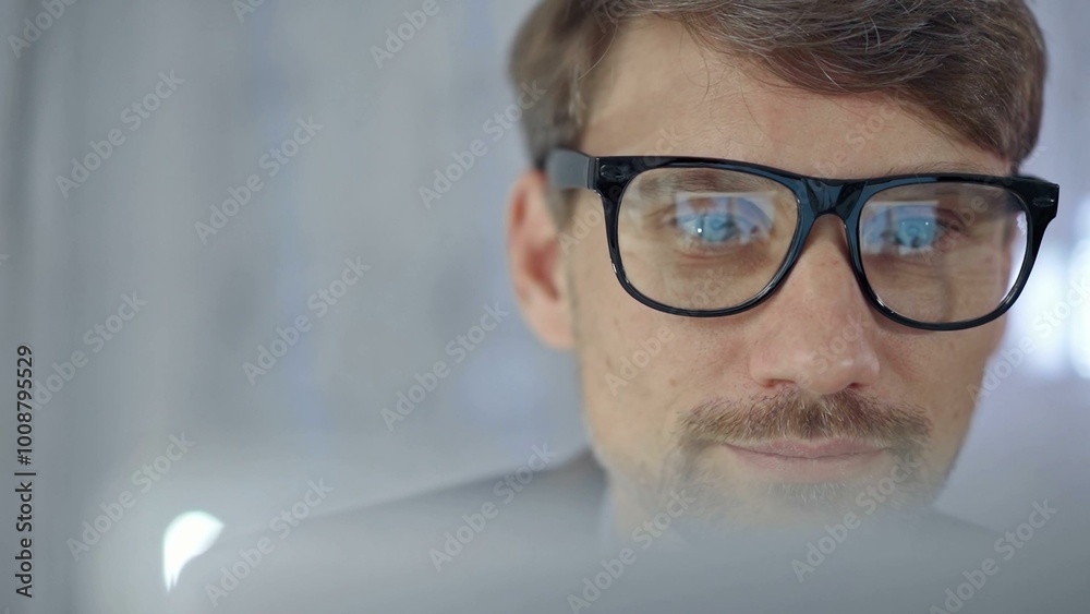 Businessman with glasses looking intently obscured partially by a translucent surface of laptop. Business people concept Businessman with glasses looking intently obscured partially by a translucent surface of laptop. Business people concept