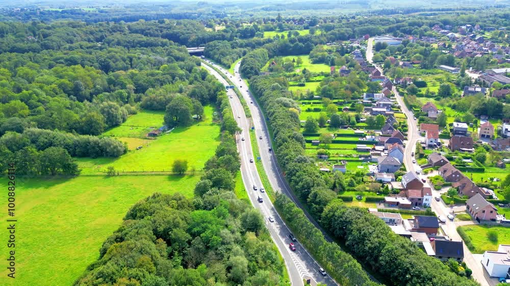 Halle, Vlaams-Brabant, Belgium, 1st of September, 2024, A stunning aerial shot of a long, winding, picturesque highway surrounded by lush, vibrant greenery and charming homes Halle, Vlaams-Brabant, Belgium, 1st of September, 2024, A stunning aerial shot of a long, winding, picturesque highway surrounded by lush, vibrant greenery and charming homes