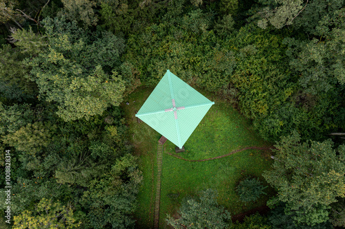 Overhead perspective of a observation tower cabin nestled in lush woodland during daylight hours. photo