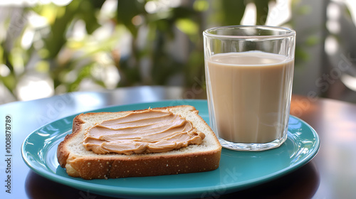 A slice of toast spread with peanut butter on a blue plate, accompanied by a glass of milk. photo