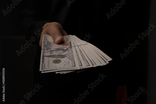 Businessman Showing Cash Spread on black background. isolated background money held in hand. photo