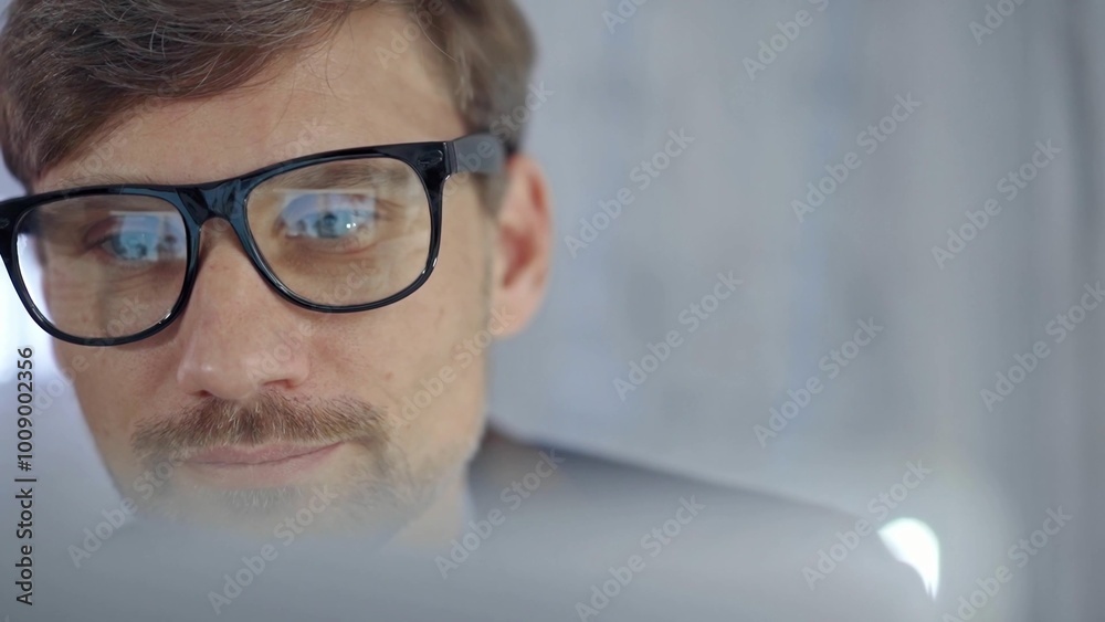 Businessman with glasses looking intently obscured partially by a translucent surface of laptop. Business people concept Businessman with glasses looking intently obscured partially by a translucent surface of laptop. Business people concept