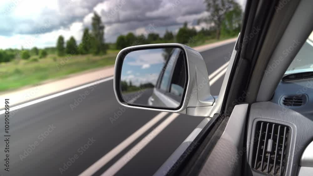 A car drives along a picturesque highway under cloudy skies A car drives along a picturesque highway under cloudy skies