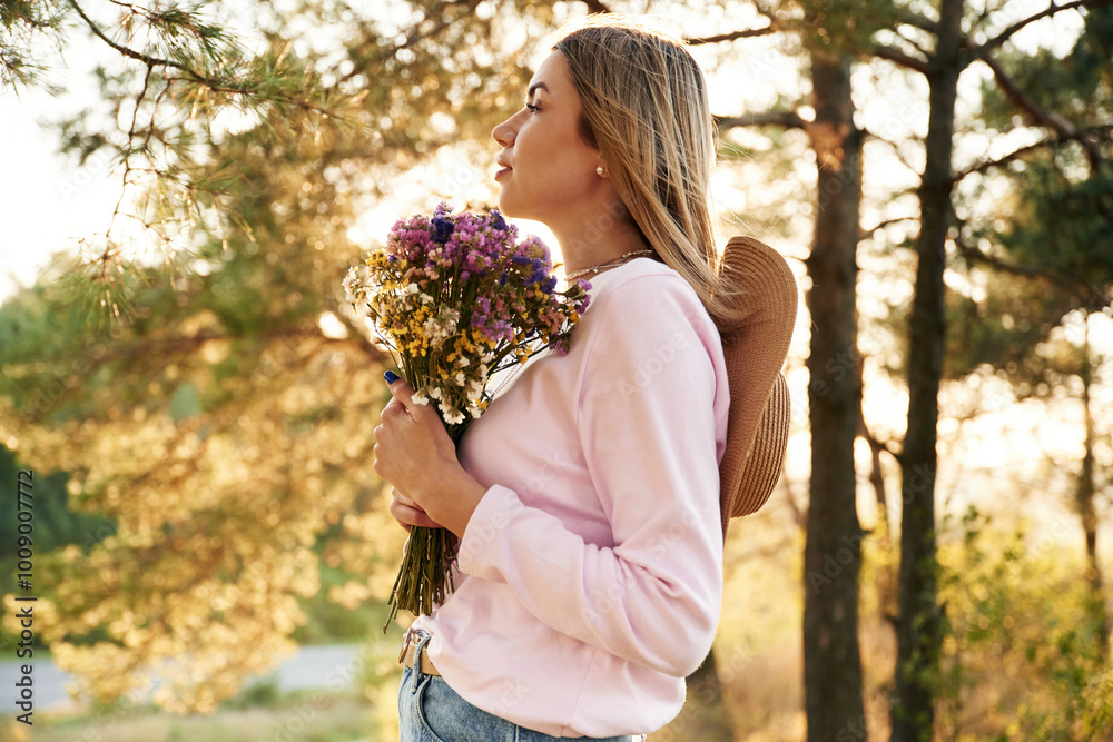 Heartfelt feelings, with bouquet with flowers. Woman is outdoors in nature with bouquet of flowers