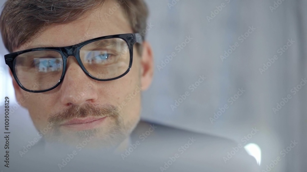 Businessman with glasses looking intently obscured partially by a translucent surface of laptop. Business people concept Businessman with glasses looking intently obscured partially by a translucent surface of laptop. Business people concept