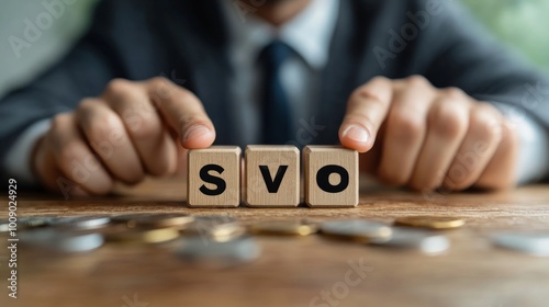 A businessman's hands arranging wooden blocks spelling out 