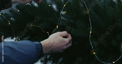 Christmas mood. A couple in love decorates a Christmas tree on the roof of their car with garlands.
