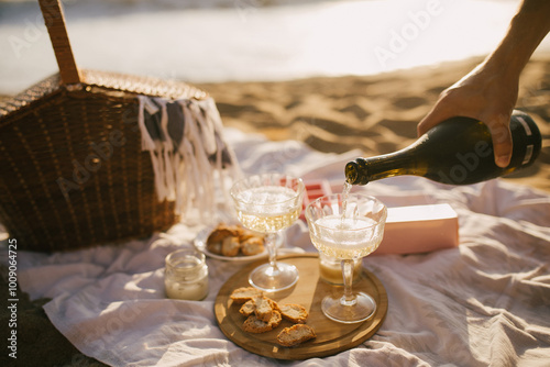 Beautiful summer picnic with champagne at sunset on the beach.