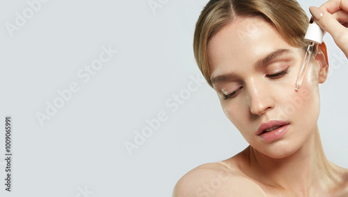 Portrait of a young woman without makeup, with natural skin texture, using a cosmetic pipette to apply serum. Minimal retouching, emphasis on natural beauty and skin care.
Advertising concept. 