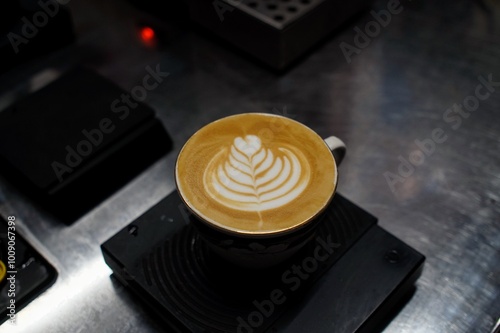 A latte art tulip 7 stack in a mug on stainless steel table, on the scales