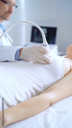 Doctor man wearing blue protective gloves is using ultrasound equipment on the breast of a female patient. Mammary gland health. Medicine concept photo