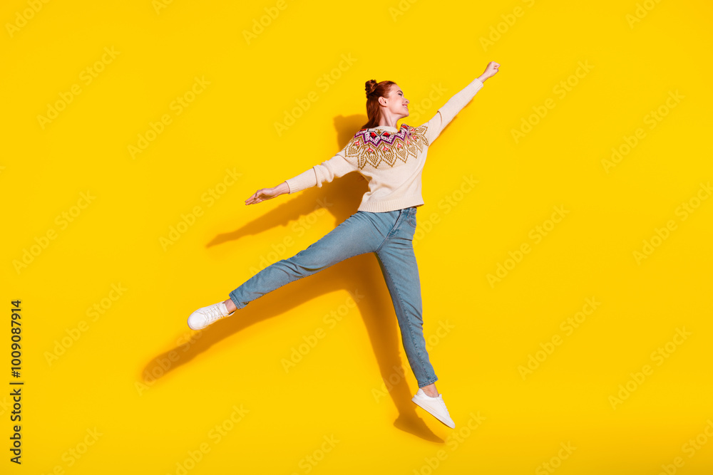 Photo portrait of attractive young woman jump fly superhero dressed stylish knitted warm outfit isolated on yellow color background Photo portrait of attractive young woman jump fly superhero dressed stylish knitted warm outfit isolated on yellow color background