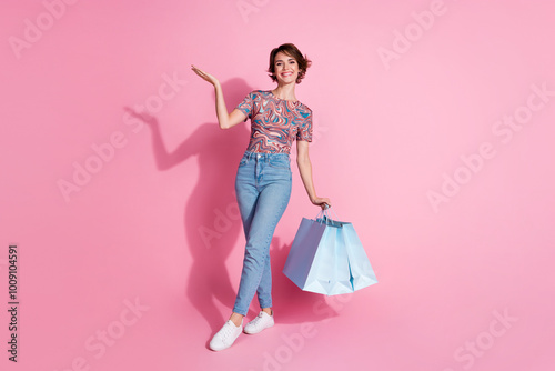 Photo of lovely gorgeous nice girl wear stylish print clothes recommend empty space isolated on pink color background