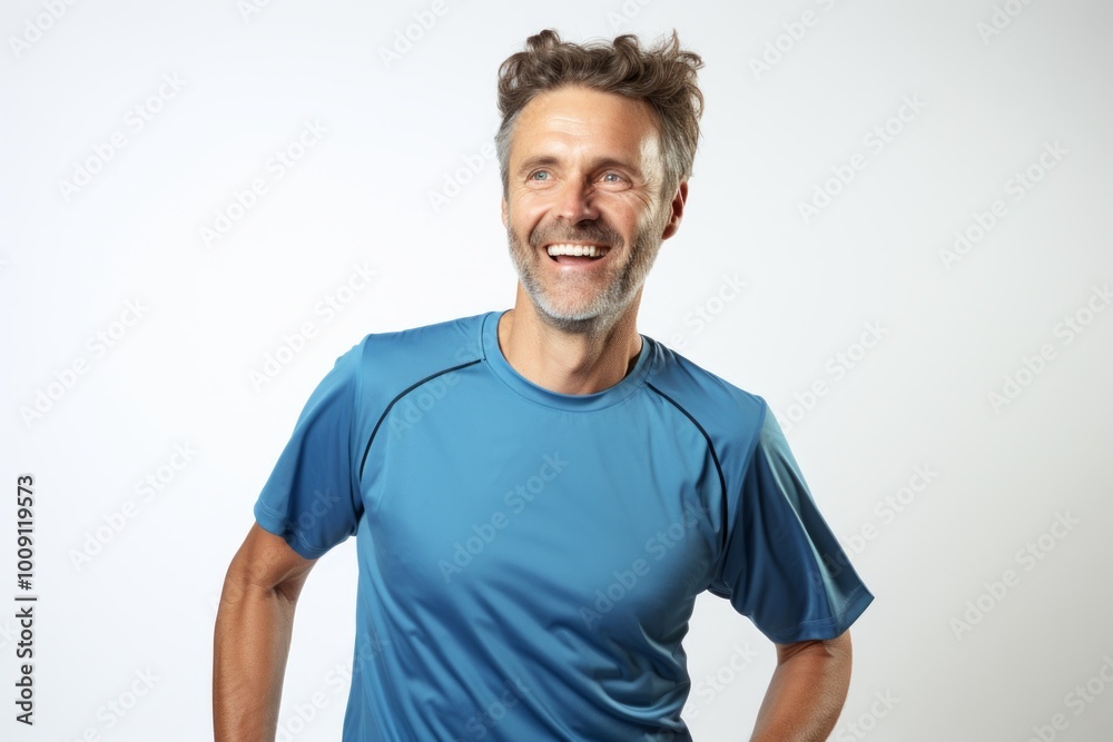 Obraz premium Portrait of a joyful man in his 40s wearing a moisture-wicking running shirt while standing against white background
