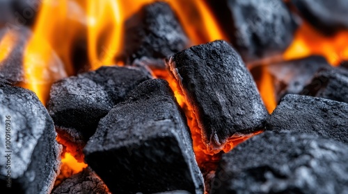 Vivid imagery of charcoal coals glowing hotly under intense orange flames, evoking feelings of warmth, dynamism, and the primal power of fire's essence. photo