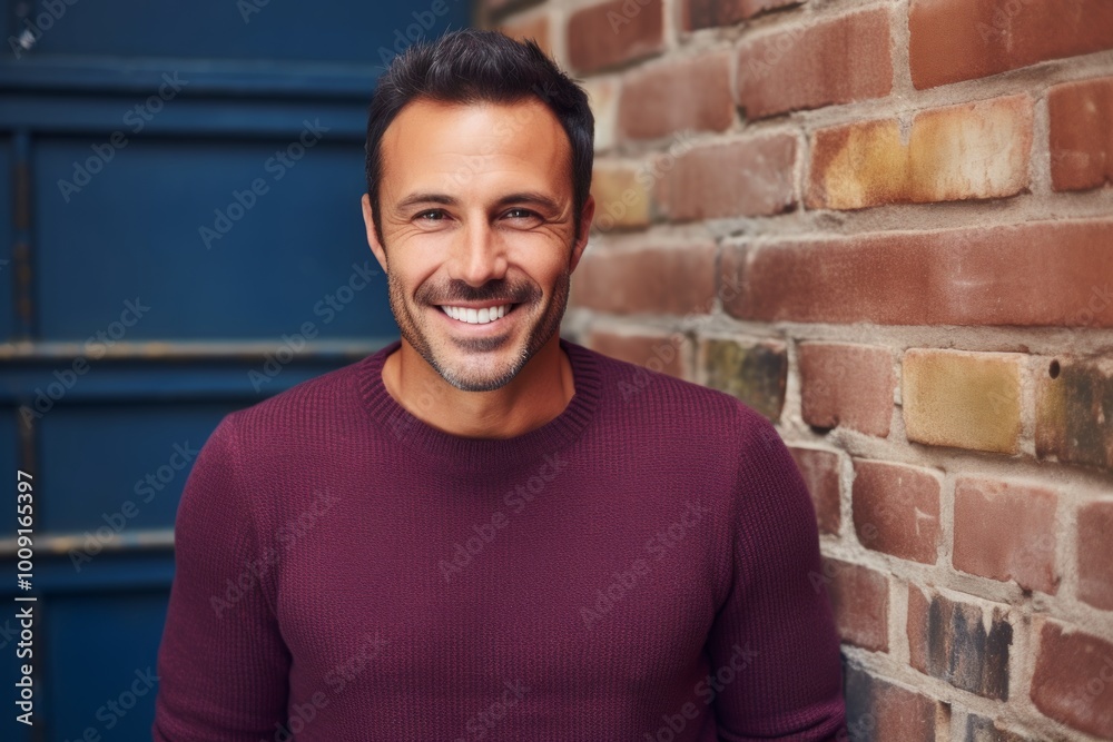 Obraz premium Portrait of a cheerful man in his 40s wearing a thermal fleece pullover on vintage brick wall