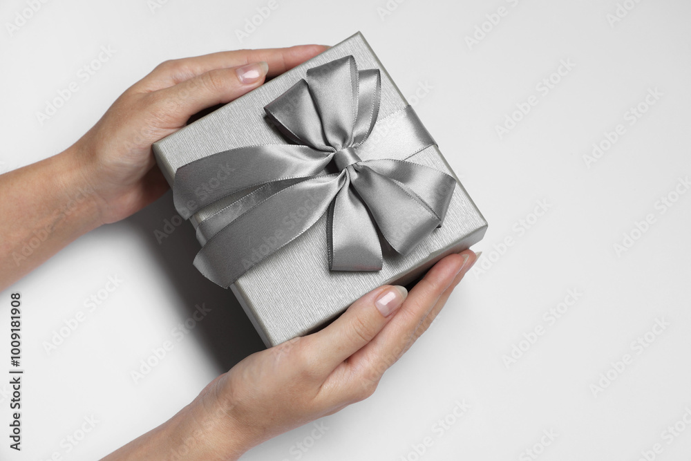 Woman holding gift box with bow on white background, closeup Woman holding gift box with bow on white background, closeup
